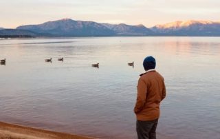person looking out at lake tahoe at dusk
