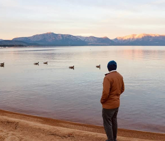 person looking out at lake tahoe at dusk