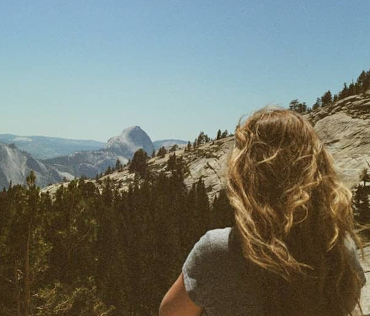 Back of a woman looking out at mountain view
